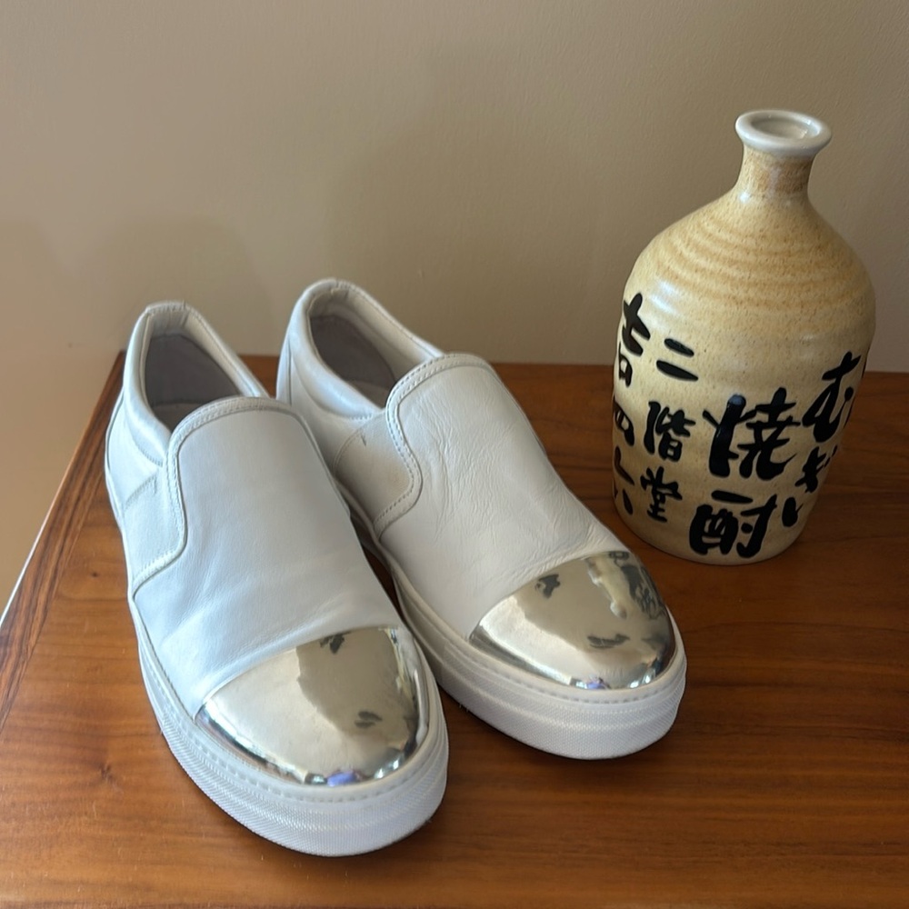 Le Blanc white leather sneakers with a gleaming silver toecap.